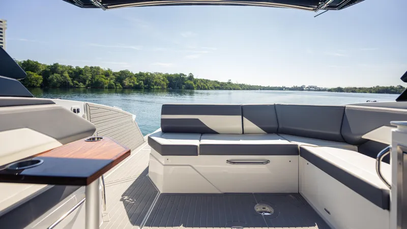  Yacht Photos Pics Luxurious seating area on 2021 Cruisers Yachts 38 GLS OB 450R, overlooking serene water and lush greenery.