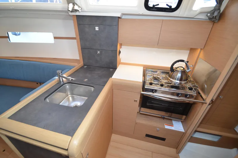 Sea To Summit Yacht Photos Pics Modern kitchen in 2022 Jeanneau Sun Odyssey 349 yacht with sink, stove, and kettle.