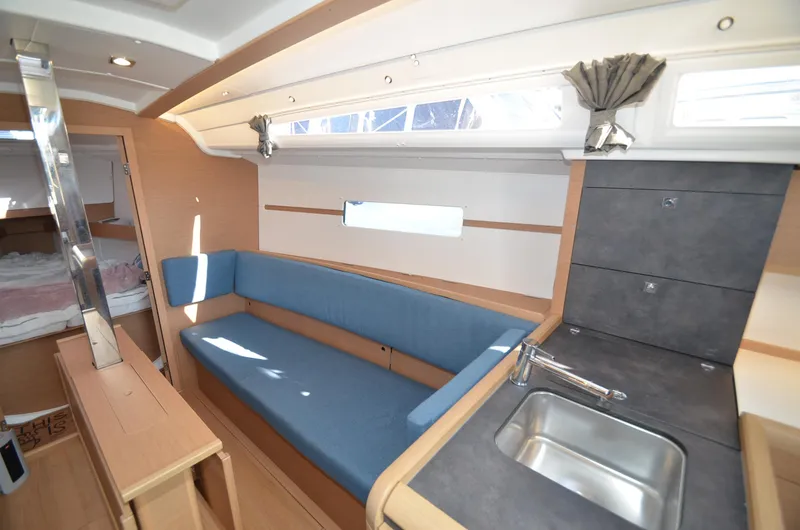Sea To Summit Yacht Photos Pics Interior of 2022 Jeanneau Sun Odyssey 349 sailboat with blue seating and compact kitchen.