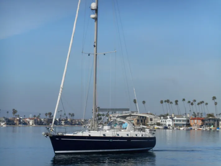 Eventus Yacht Photos Pics Beneteau Oceanis 50 sailboat from 2000 on calm waters near a coastal town.