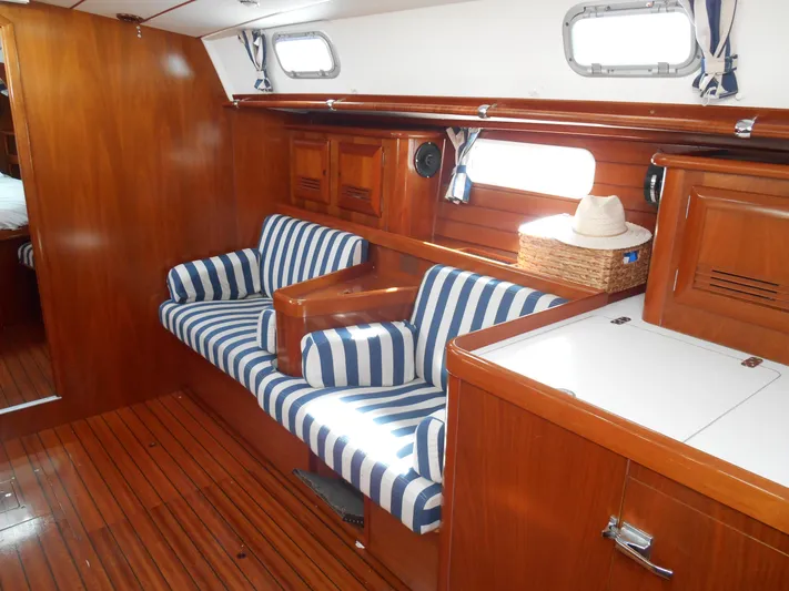 Eventus Yacht Photos Pics Interior of 2000 Beneteau Oceanis 50 yacht with striped seating and wooden finishes.