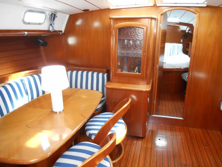 Eventus Yacht Photos Pics Interior of 2000 Beneteau Oceanis 50 yacht with wooden furnishings and striped seating.