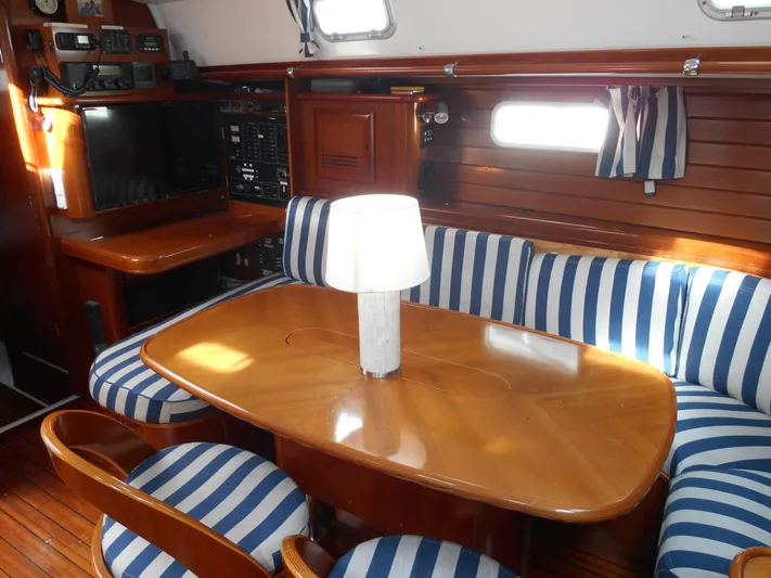 Eventus Yacht Photos Pics Interior of 2000 Beneteau Oceanis 50 yacht with striped seating and wooden table.