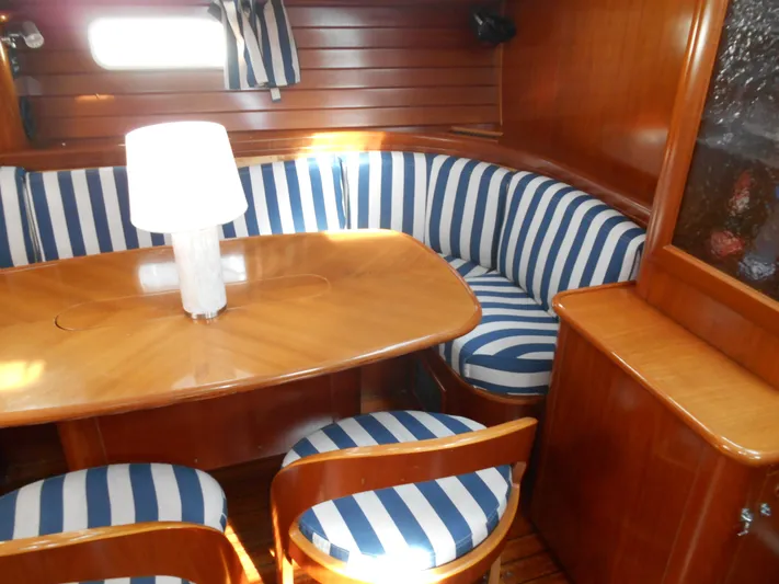 Eventus Yacht Photos Pics Interior of 2000 Beneteau Oceanis 50 with striped seating and wooden table.
