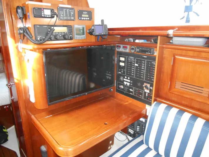 Eventus Yacht Photos Pics Navigation station of 2000 Beneteau Oceanis 50 yacht with control panels and striped seating.