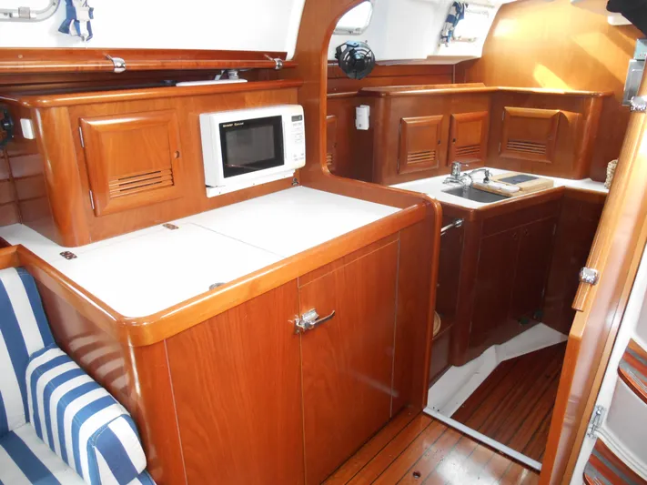 Eventus Yacht Photos Pics Interior of 2000 Beneteau Oceanis 50 yacht with wooden cabinetry and compact kitchen area.
