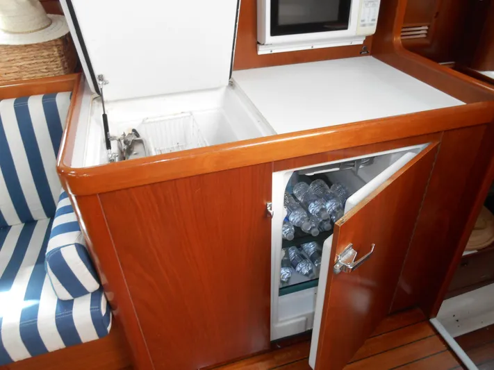 Eventus Yacht Photos Pics Interior of 2000 Beneteau Oceanis 50 yacht with fridge and striped seating.