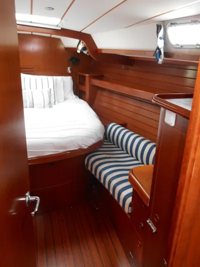 Eventus Yacht Photos Pics Cozy cabin interior of 2000 Beneteau Oceanis 50 with striped seating and wooden finish.