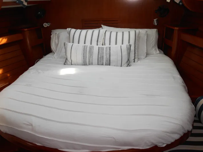 Eventus Yacht Photos Pics Cozy cabin bed in 2000 Beneteau Oceanis 50 sailboat with striped pillows.