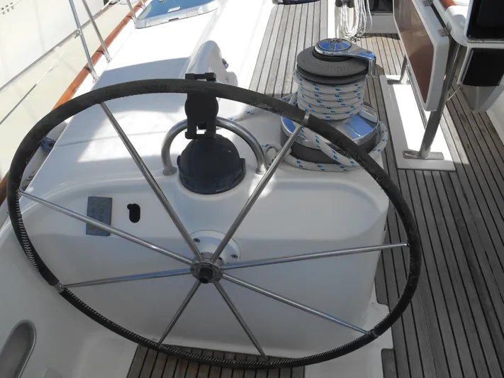 Eventus Yacht Photos Pics Steering wheel of a 2000 Beneteau Oceanis 50 sailboat on a wooden deck.