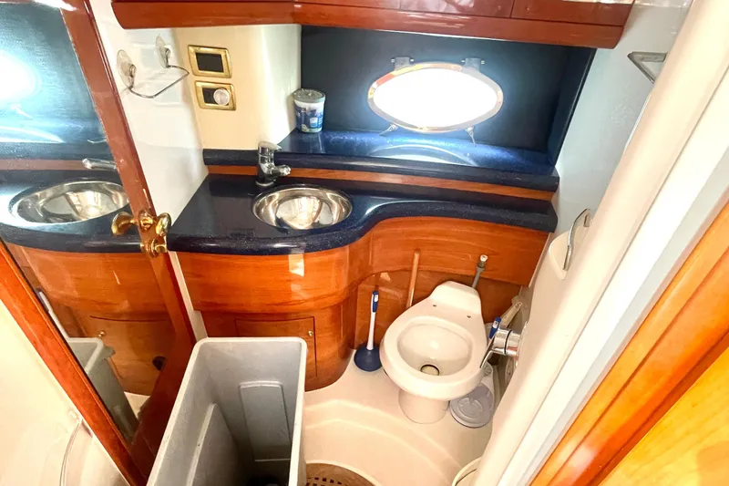 Saphir Bleu Yacht Photos Pics Luxurious bathroom in 2006 Cranchi Mediterranee 50 HT yacht with wooden cabinetry and modern fixtures.