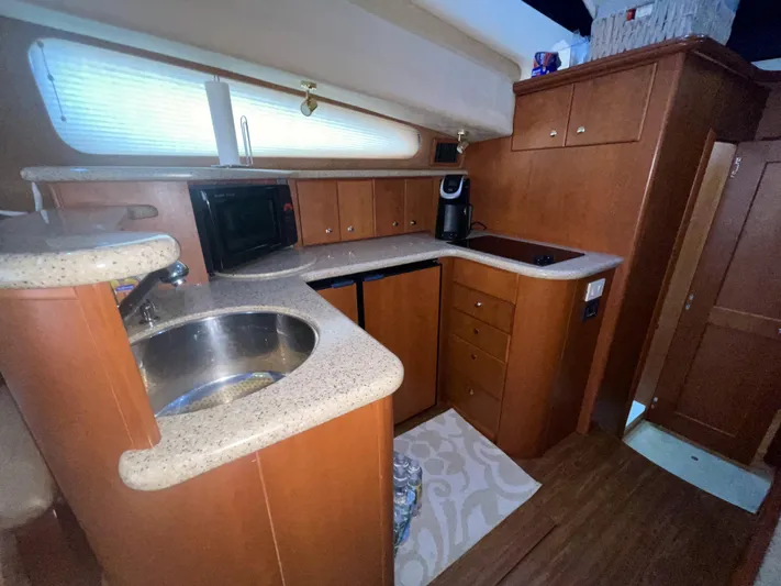 Knot On Call II Yacht Photos Pics 2006 Silverton 43 Sport Bridge kitchen with wood cabinetry and modern appliances.