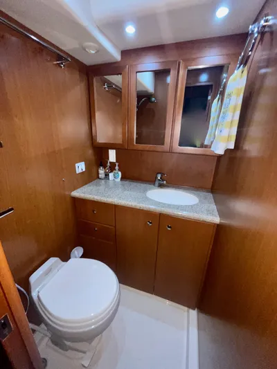 Knot On Call II Yacht Photos Pics 2006 Silverton 43 Sport Bridge bathroom with wood cabinetry and modern fixtures.
