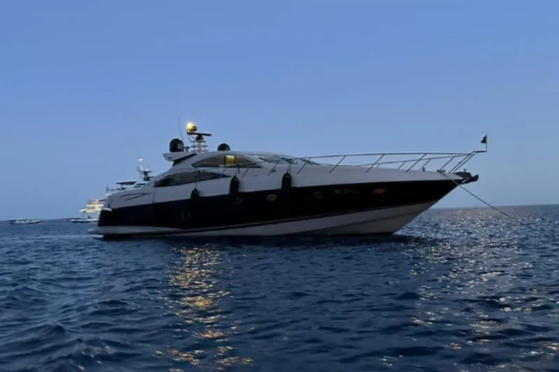  Yacht Photos Pics 2007 Sunseeker Predator 72 yacht anchored on calm sea at dusk.