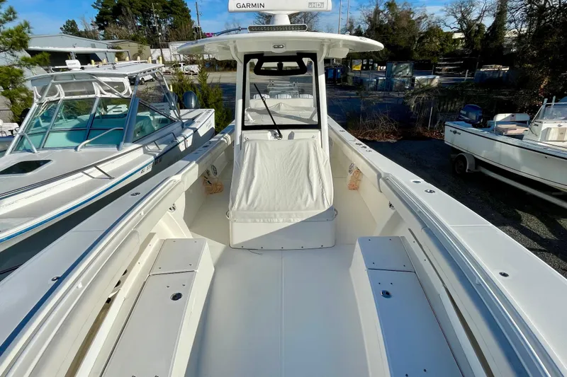  Yacht Photos Pics 2023 Regulator 34 boat with spacious deck and modern design in a marina setting.