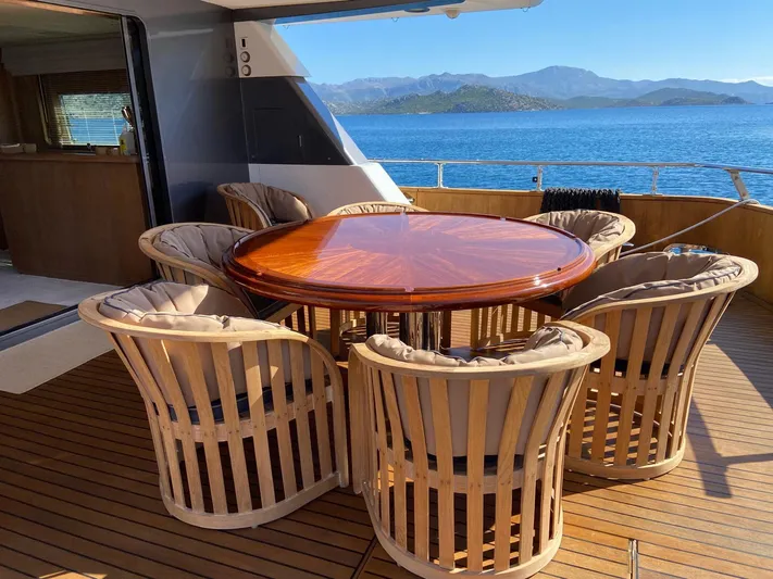  Yacht Photos Pics Luxury yacht deck with round wooden table and cushioned chairs, Cantieri di Pisa Akhir 30S, 1992.
