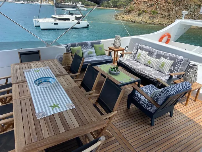  Yacht Photos Pics Luxurious yacht deck with elegant seating, dining area, and scenic ocean view. Cantieri di Pisa Akhir 30S.