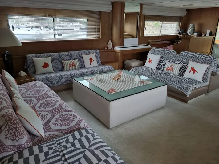  Yacht Photos Pics Luxurious yacht interior with patterned sofas, glass table, and nautical-themed decor.