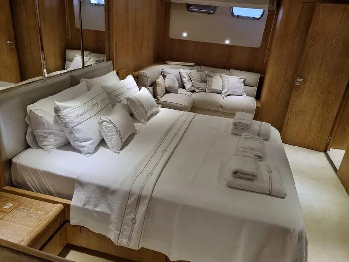  Yacht Photos Pics Luxurious bedroom interior on 1992 Cantieri di Pisa Akhir 30S yacht, featuring elegant bedding and cozy seating.