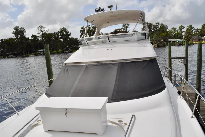 King Leisure Yacht Photos Pics 2002 Sea Ray 480 Sedan Bridge yacht docked on a serene lake.