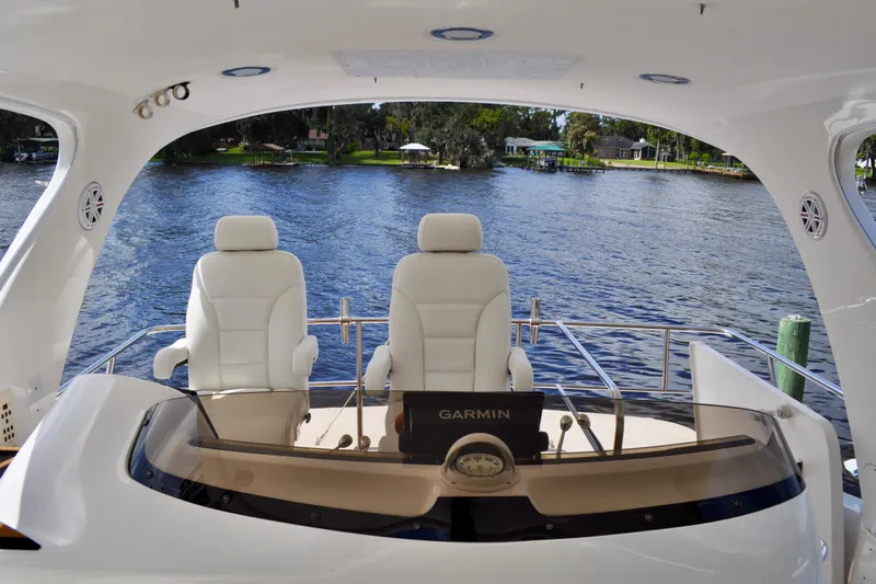 King Leisure Yacht Photos Pics 2002 Sea Ray 480 Sedan Bridge yacht helm with Garmin navigation, overlooking serene waters.