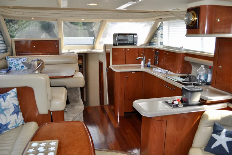King Leisure Yacht Photos Pics Luxurious interior of 2002 Sea Ray 480 Sedan Bridge yacht with modern kitchen and seating area.