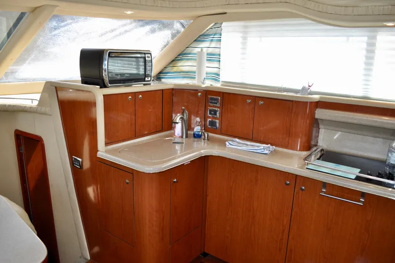 King Leisure Yacht Photos Pics 2002 Sea Ray 480 Sedan Bridge yacht kitchen with wood cabinets and modern appliances.