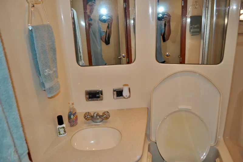 King Leisure Yacht Photos Pics Bathroom interior of 2002 Sea Ray 480 Sedan Bridge yacht, featuring sink and mirrors.