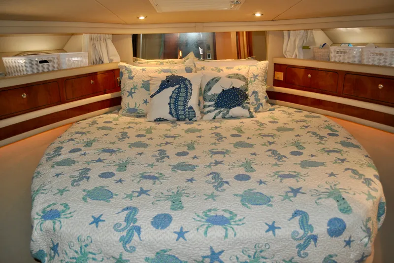 King Leisure Yacht Photos Pics Luxurious 2002 Sea Ray 480 Sedan Bridge cabin with nautical-themed bedding and elegant wood cabinetry.