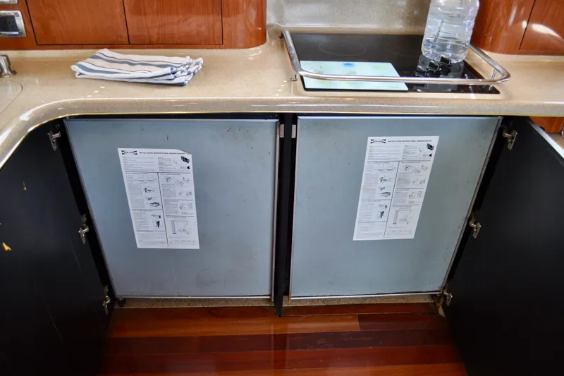 King Leisure Yacht Photos Pics Kitchen area of 2002 Sea Ray 480 Sedan Bridge with open cabinets and countertop items.