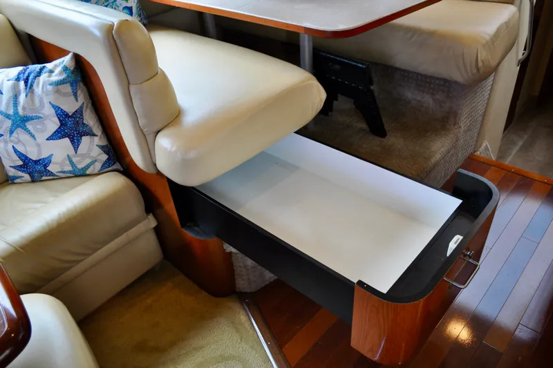 King Leisure Yacht Photos Pics Interior of 2002 Sea Ray 480 Sedan Bridge with open storage drawer and starfish-patterned pillow.