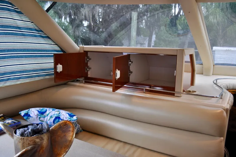 King Leisure Yacht Photos Pics Interior of 2002 Sea Ray 480 Sedan Bridge with open wooden cabinets and cushioned seating.