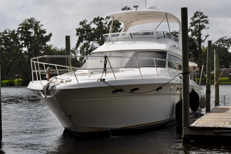 King Leisure Yacht Photos Pics 2002 Sea Ray 480 Sedan Bridge yacht docked on a calm river.