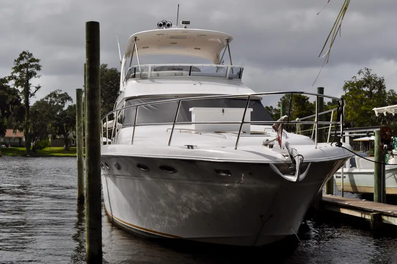 King Leisure Yacht Photos Pics 2002 Sea Ray 480 Sedan Bridge yacht docked on a calm river.