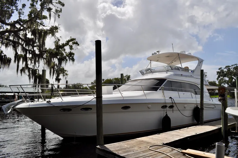 King Leisure Yacht Photos Pics 2002 Sea Ray 480 Sedan Bridge yacht docked by a scenic waterfront.