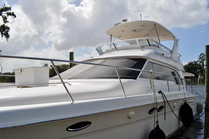 King Leisure Yacht Photos Pics 2002 Sea Ray 480 Sedan Bridge yacht docked under cloudy sky.