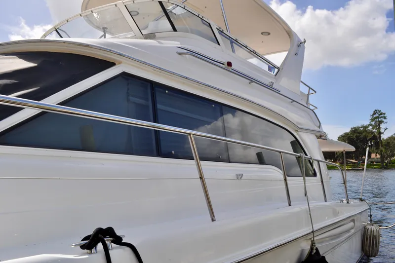 King Leisure Yacht Photos Pics 2002 Sea Ray 480 Sedan Bridge yacht docked by a scenic waterfront.