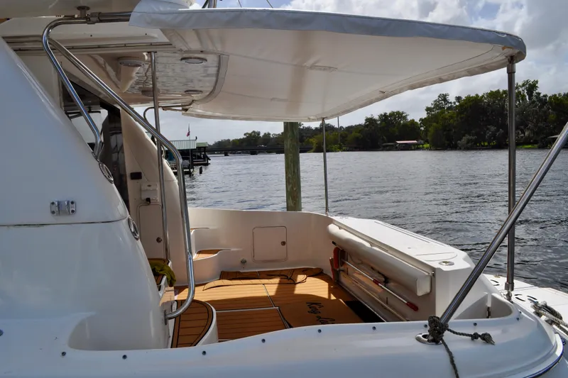 King Leisure Yacht Photos Pics 2002 Sea Ray 480 Sedan Bridge yacht with spacious deck and canopy on a serene river.