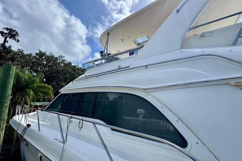 King Leisure Yacht Photos Pics 2002 Sea Ray 480 Sedan Bridge yacht docked under a cloudy sky.