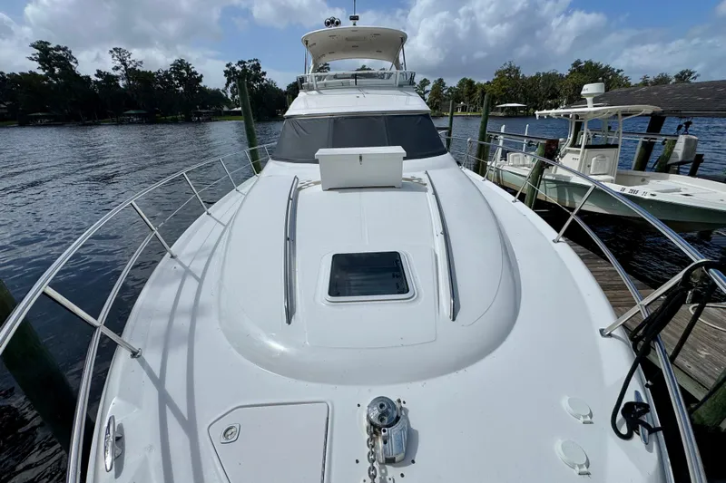 King Leisure Yacht Photos Pics 2002 Sea Ray 480 Sedan Bridge yacht docked on a serene waterfront.