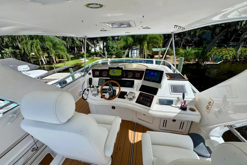 King Leisure Yacht Photos Pics 2002 Sea Ray 480 Sedan Bridge helm with modern controls and scenic waterfront view.