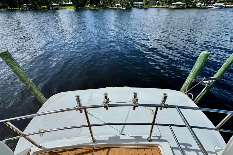 King Leisure Yacht Photos Pics 2002 Sea Ray 480 Sedan Bridge yacht docked by a serene waterfront.