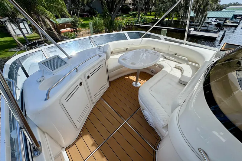 King Leisure Yacht Photos Pics 2002 Sea Ray 480 Sedan Bridge yacht with spacious outdoor seating and table on deck.