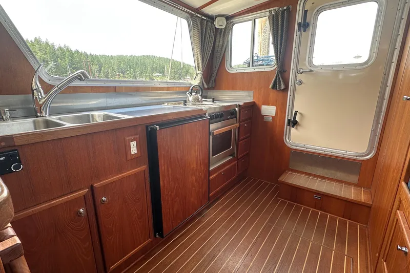 Blue Heron Yacht Photos Pics Interior of 2003 Coastal Craft 320 Cruiser with wood finish and kitchen amenities.
