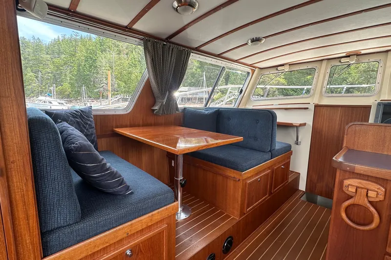 Blue Heron Yacht Photos Pics Interior of 2003 Coastal Craft 320 Cruiser with wood finish and blue seating.