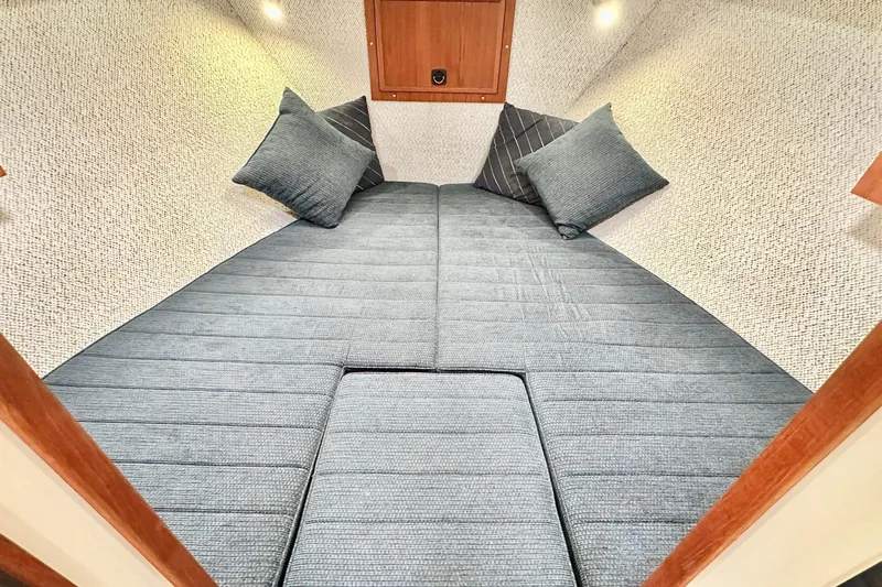 Blue Heron Yacht Photos Pics Cozy cabin interior of 2003 Coastal Craft 320 Cruiser with plush bedding and cushions.