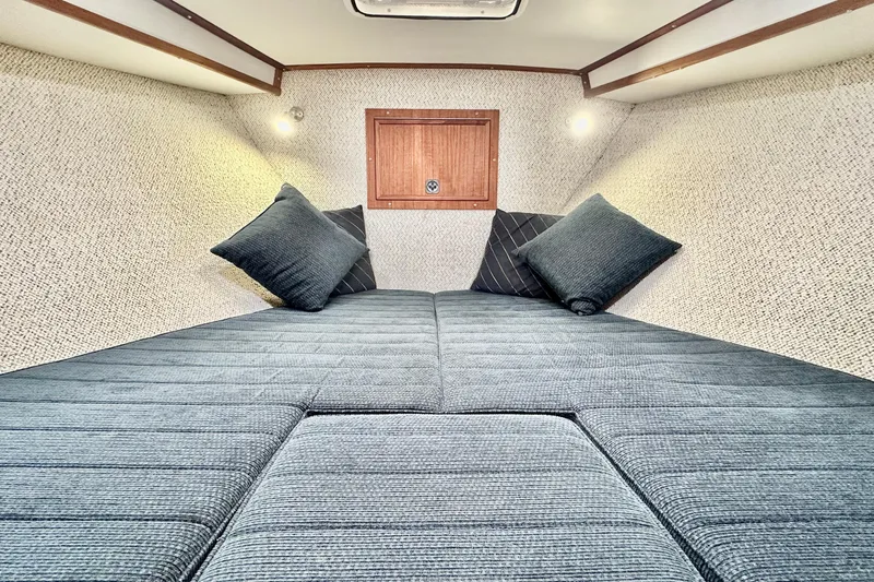Blue Heron Yacht Photos Pics Interior cabin of 2003 Coastal Craft 320 Cruiser with cozy bedding and cushions.