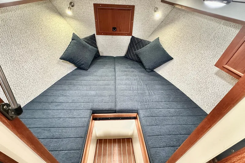 Blue Heron Yacht Photos Pics Cozy cabin interior of 2003 Coastal Craft 320 Cruiser with blue cushions and wooden accents.