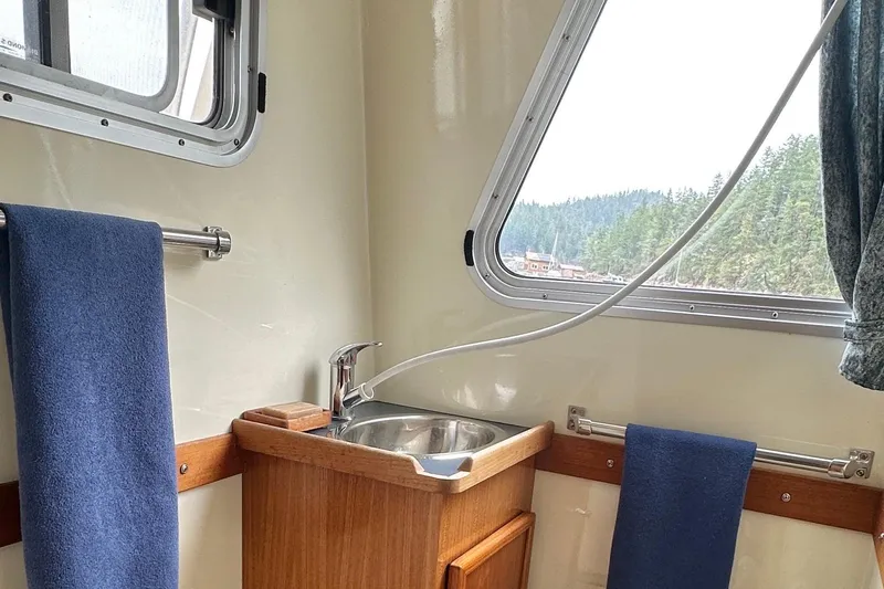 Blue Heron Yacht Photos Pics Interior of 2003 Coastal Craft 320 Cruiser with sink, window, and blue towels.