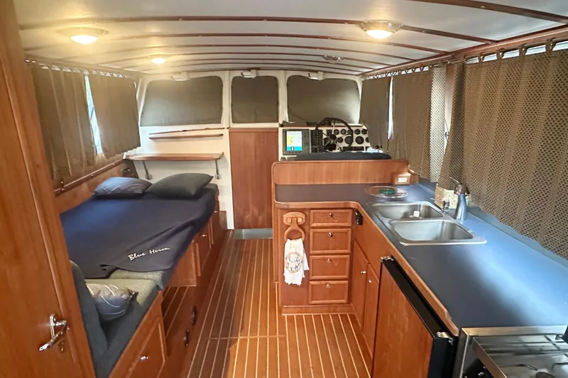 Blue Heron Yacht Photos Pics Interior of 2003 Coastal Craft 320 Cruiser with cozy bed, kitchenette, and navigation area.